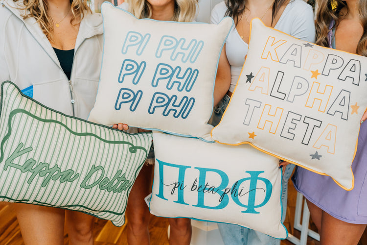 college students holding sorority pillows